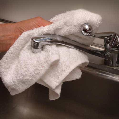 White Terry Rag Wiping a Faucet